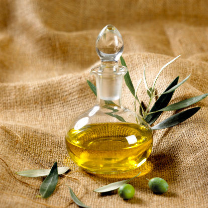 Green olives and olive oil on sackcloth